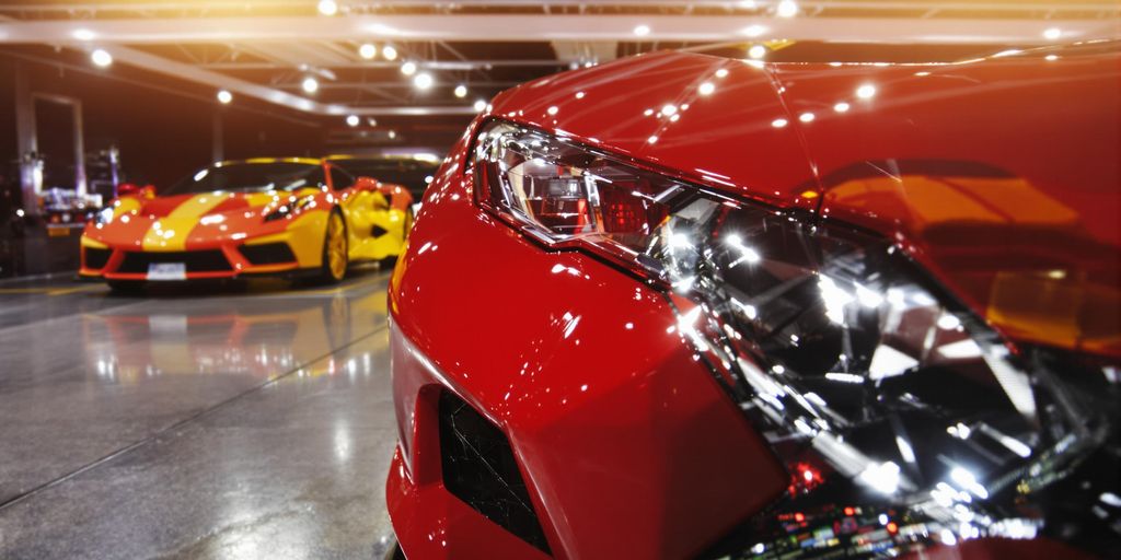 Sleek, powerful supercars parked under bright lights.