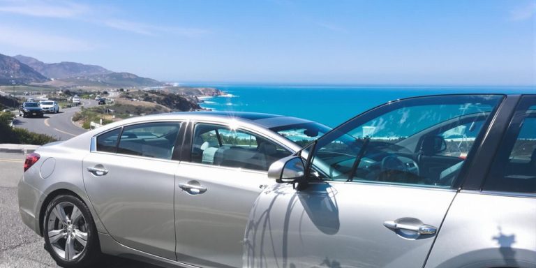 Rental car parked on a scenic coastal road.
