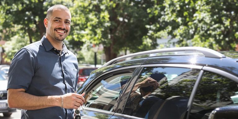 Man standing by affordable rental car.